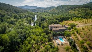 - une vue aérienne sur une maison dans les montagnes avec une cascade dans l'établissement Le Mas de Roussa, à Meyrannes