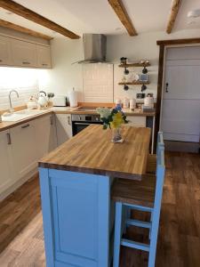 a kitchen with a wooden table with a vase of flowers on it at Seaview Cottage in Bridlington