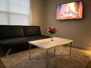 a living room with a couch and a table with flowers on it at City Modern Apartment in Charlottetown