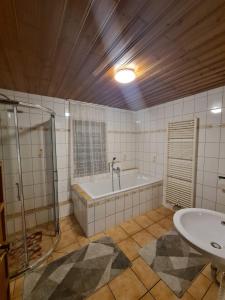 bagno con vasca e lavandino di Ferienhaus Auszeit a Seebach