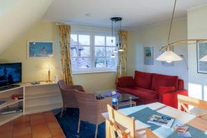 ein Wohnzimmer mit einem roten Sofa und einem Tisch in der Unterkunft Ferienwohnung Brise in Wyk auf Föhr