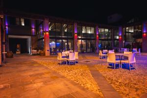 a group of tables and chairs in a courtyard at night at Tenuta Canova in Cologno al Serio