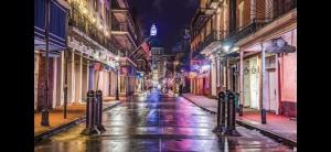 an empty city street at night with lights at Best Location, Walk Anywhere in New Orleans