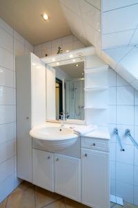 a white bathroom with a sink and a mirror at Ferienwohnung Südstrand in Wyk auf Föhr