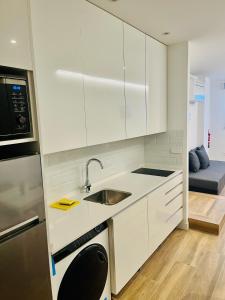 una cocina con armarios blancos y fregadero en BERNABEU/ C.UNIVERSITARIA APARTMENTS en Madrid