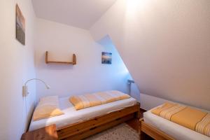 ヴィーク・アウフ・フェールにあるFerienwohnung Brittaの小さな部屋で、屋根裏部屋にベッド2台が備わります。