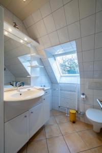 a bathroom with a sink and a toilet and a window at Ferienwohnung Südstrand in Wyk auf Föhr
