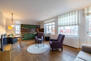 a kitchen and living room with chairs and a table at Villa Friedericia, Wohnung 3-Hochparterre links in Wyk auf Föhr