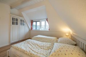 a bedroom with two beds and a window at Ferienwohnung Oldsum in Oldsum
