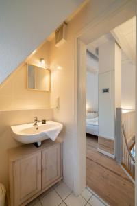 uma casa de banho com um lavatório e uma escada em Ferienwohnung Oldsum em Oldsum