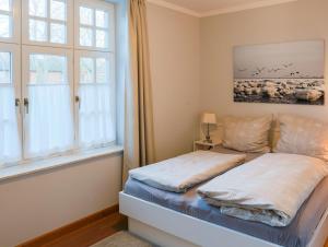ein Schlafzimmer mit einem Bett und einem Fenster in der Unterkunft Villa Friedericia, Wohnung 3-Hochparterre links in Wyk auf Föhr
