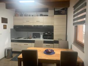 een eettafel met stoelen en een keuken bij Green Garden Lohovo in Bihać