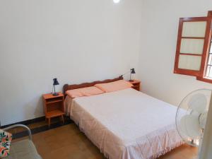 1 dormitorio con cama, espejo y ventana en Casa a 3 cuadras del mar, zona centro en Villa Gesell