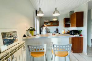 cocina con 2 sillas y encimera en Ma Petite Maison, en Chasse-sur-Rhône