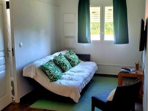 een kamer met een bank met kussens en een raam bij Saint Rose : Charmant T3 proche de la plage in Plessis-Nogent