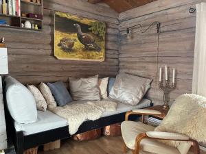 ein Wohnzimmer mit einem Sofa in einer Holzwand in der Unterkunft Buhaug - cabin at Sjusjøen in Ringsaker