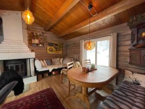 ein Wohnzimmer mit einem Tisch und einem Kamin in der Unterkunft Buhaug - cabin at Sjusjøen in Ringsaker