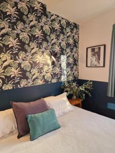 Schlafzimmer mit einem Bett mit einer schwarz-weißen Tapete in der Unterkunft Les Lauriers in Saint-Tropez