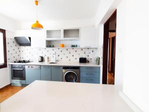 a kitchen with blue cabinets and a washing machine at Ertem Apart in Datca