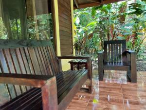 2 bancs assis sur la terrasse couverte d'une maison dans l'établissement Casita Lidia Bijagua, à Bijagua 21 autres photos