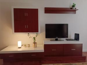 a living room with a tv on top of a cabinet at Garajau Terrace Adventure-Pool and Free Parking in Caniço