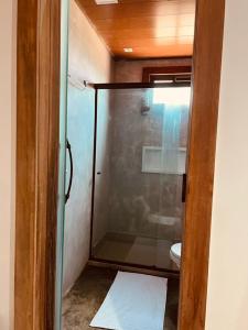 a bathroom with a glass shower with a toilet at Refúgio da Rita in Fernando de Noronha