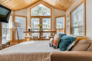 a bedroom with a bed in a room with windows at Tiny Haven Spacious Feel, BBQ & Peak Views in Woodland Park