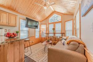 a living room with a couch and a tv and a kitchen at Tiny Haven Spacious Feel, BBQ & Peak Views in Woodland Park