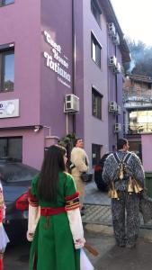 a group of people standing in front of a purple building at Къща за гости ТАТЯНА / GUEST HOUSE TATIANA in Petrich