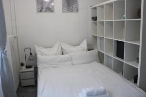 1 dormitorio con cama blanca y almohadas blancas en Schickes Appartement an der Neckarpromenade, en Heilbronn
