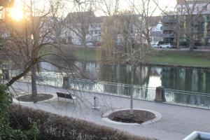 un parque con un banco junto a un cuerpo de agua en Schickes Appartement an der Neckarpromenade, en Heilbronn