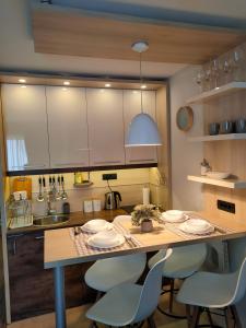 uma cozinha com mesa e cadeiras e um balcão em Tim 135 Konaci-Angella Centar em Kopaonik