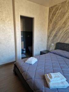 a bedroom with a bed with two towels on it at Piazza Duomo in Tuscania