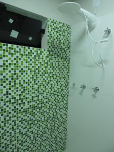 a bathroom with a shower with a green tiled wall at Pousada Vale do Parque in Cunha