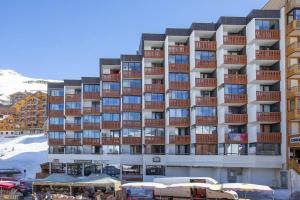 duży budynek mieszkalny naprzeciwko pokrytej śniegiem góry w obiekcie Charming studio 3 persons w Val Thorens +2 zdjęcia