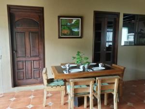 uma mesa de madeira com cadeiras e uma porta de madeira em Nacientes Lodge em Bijagua