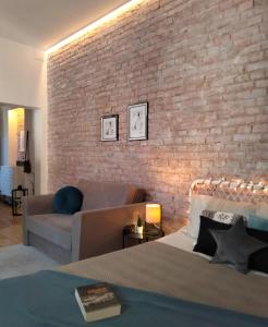 a living room with a couch and a brick wall at Apartament Za Murami Gliwice in Gliwice