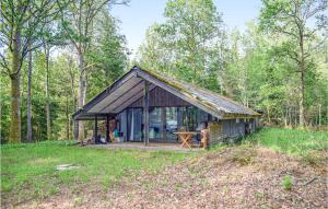 a cabin in the woods with a table in front at Awesome Home In Annerstad With 3 Bedrooms And Sauna in Annerstad