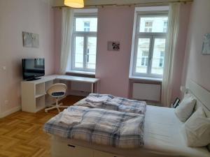 a bedroom with a bed and a desk and windows at Big Family Apartment in Vienna