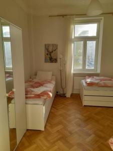 Habitación pequeña con 2 camas y ventana en Big Family Apartment en Viena