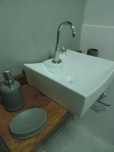 baño con lavabo blanco y vela verde en Pousada Vale do Parque, en Cunha