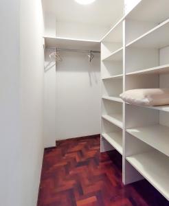 vestidor con estanterías blancas y suelo de madera en Departamento Nva. Cba. 2 habitaciones - Equipado full - Patagonian Dptos en Córdoba