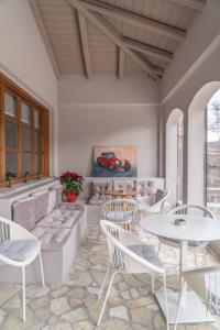 ein Zimmer mit Tischen und Stühlen und ein Gemälde eines Autos in der Unterkunft Anastasia's Suites Arcadia in Vitina