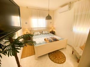 a bedroom with a bed and a plant in it at Piano & Sea view Golden Sea (Sunset view & beach) in Ashdod