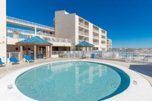 a swimming pool in front of a building at Sugar Beach 304 condo in Gulf Shores