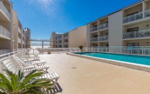 a swimming pool in a building with lounge chairs at Sugar Beach 304 condo in Gulf Shores