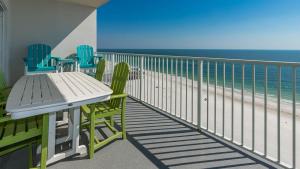 a balcony with chairs and a table and the ocean at Seawind 809 condo in Gulf Shores