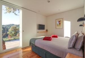 ein Schlafzimmer mit einem Bett und einem großen Fenster in der Unterkunft Encosta do Sobreiro - Serra da Estrela in Fornos de Algodres