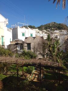 un edificio blanco con una colina al fondo en Casa Valentino, en Capri