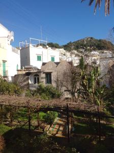 a white building with a hill in the background at Casa Valentino in Capri
